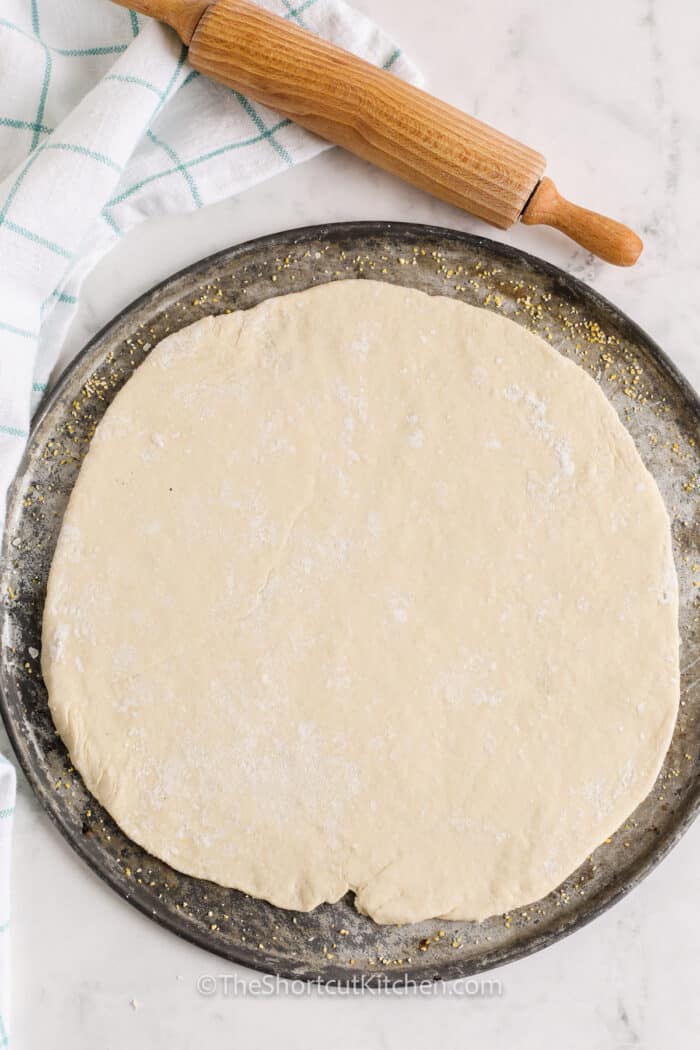 Bisquick Pizza Dough rolled out on a pizza pan