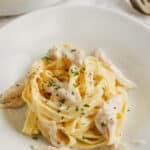 crockpot chicken alfredo served on a white plate, garnished with fresh parsley