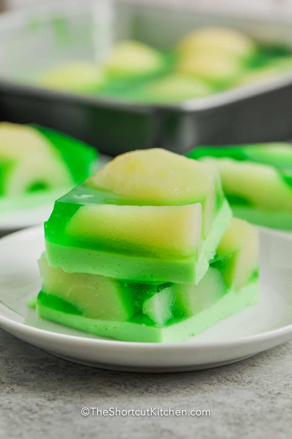 Two sliced of lime jello salad stacked