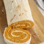 Pumpkin Roll Cake sliced on a cutting board