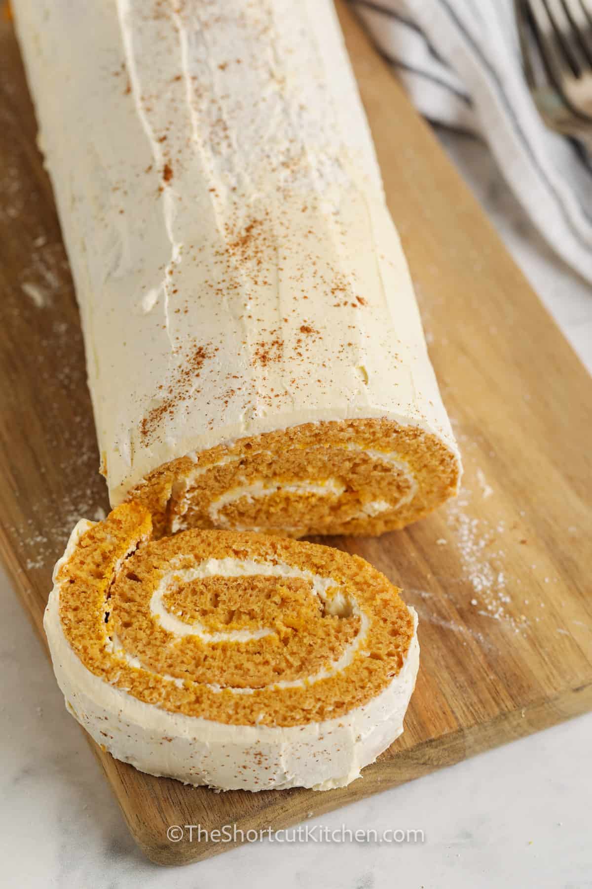 Pumpkin Roll Cake sliced on a cutting board