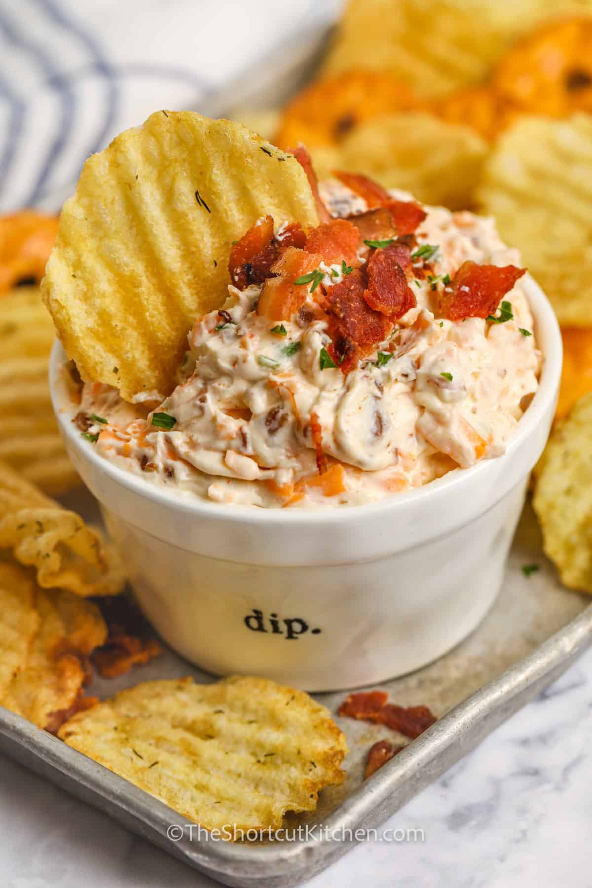 Bacon Cheddar Cream Cheese Dip being served with a chip