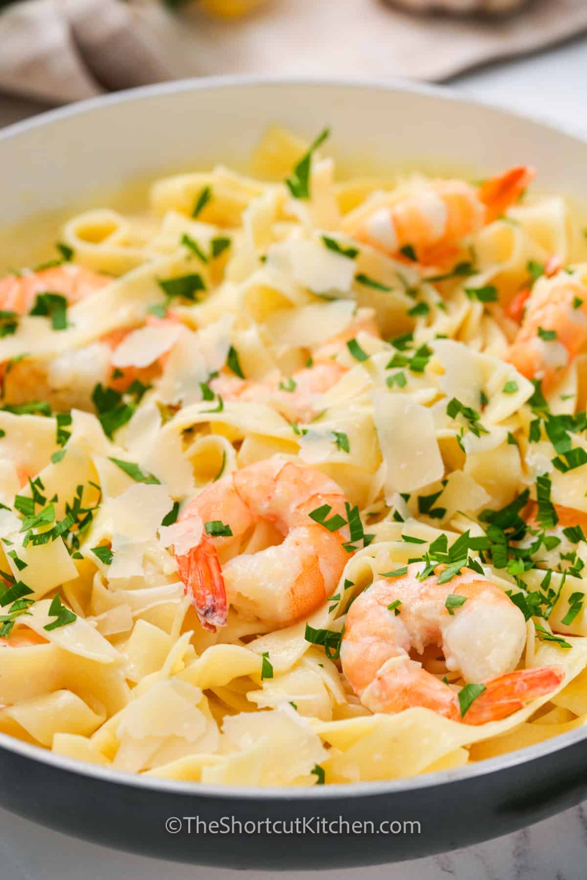 Easy Shrimp Alfredo prepared and served in a pan, garnished with fresh parsley