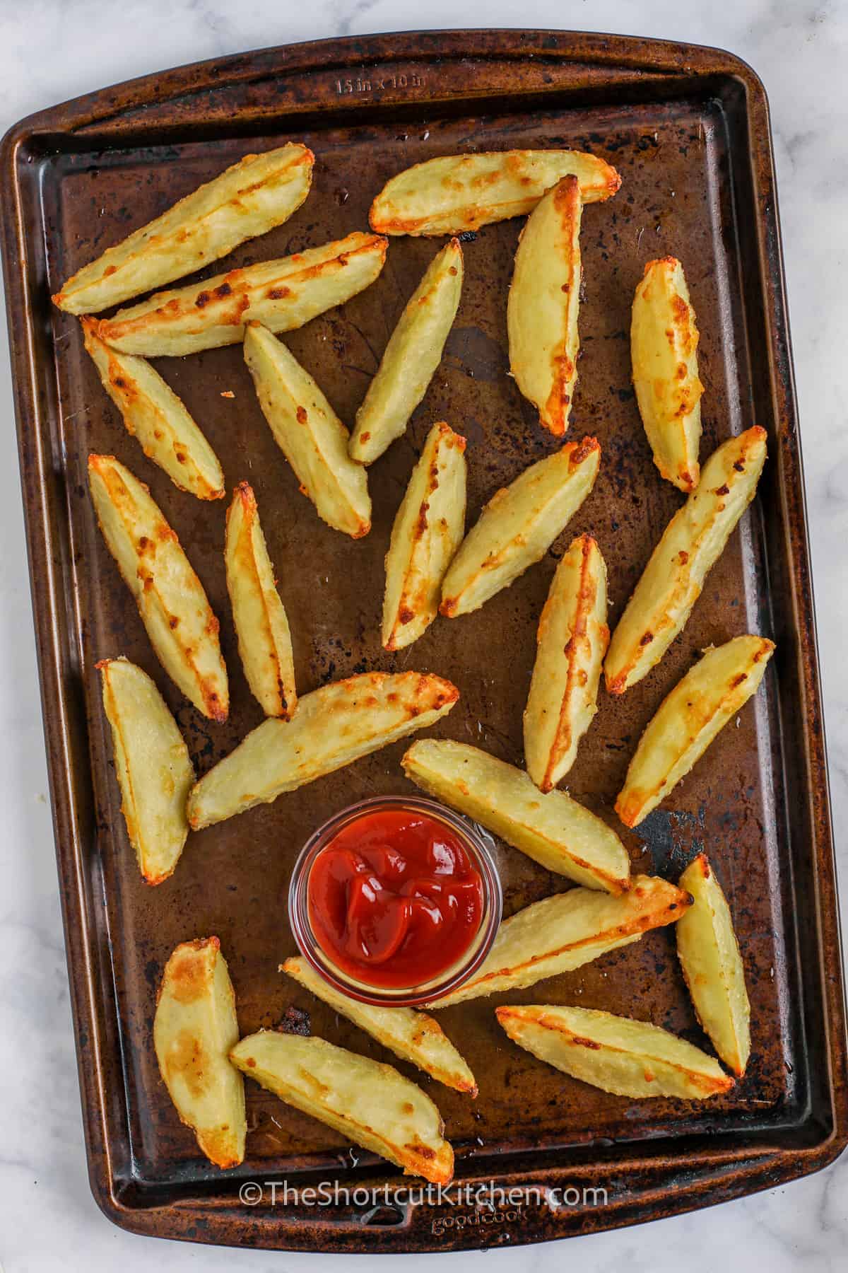Oven Baked Potato Wedges on a pan with ketchup