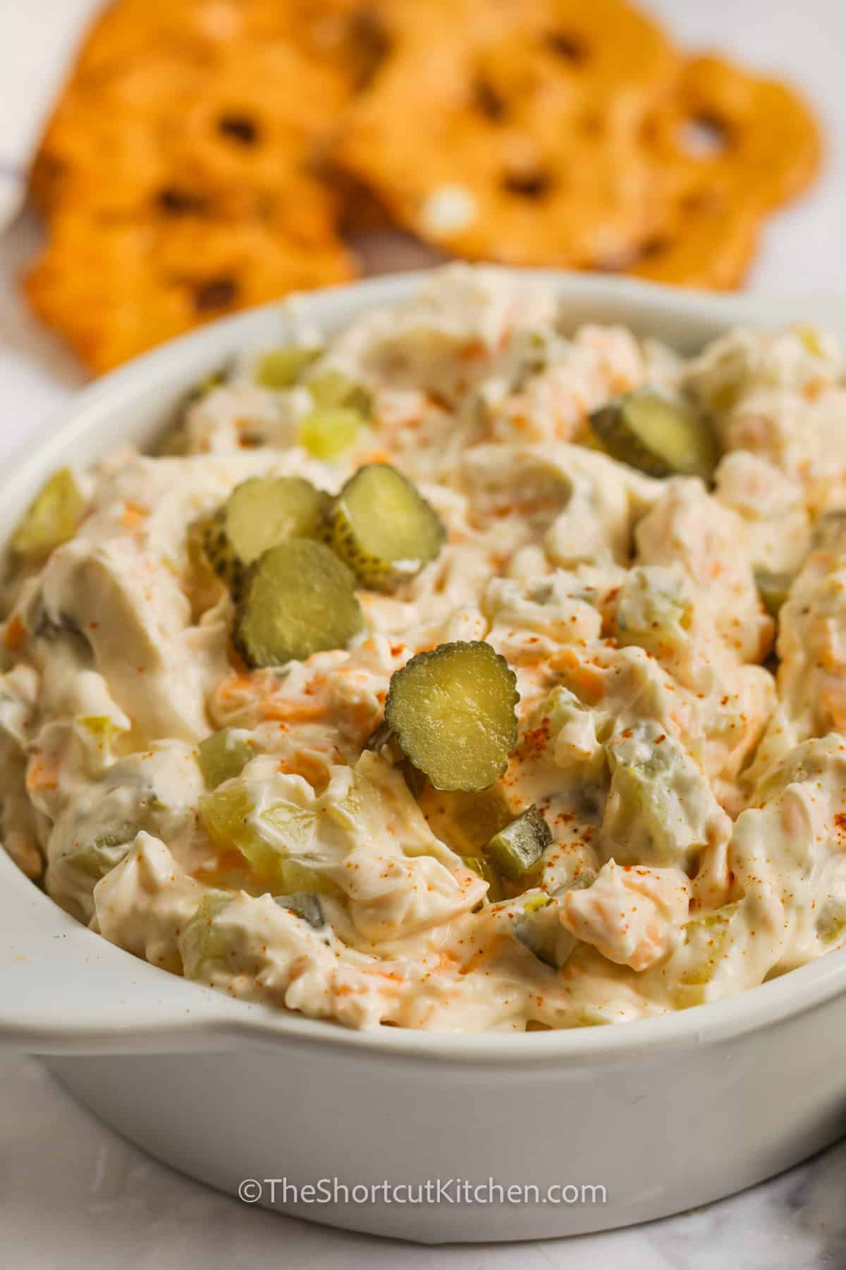 Dill Pickle Dip prepare in a serving dish with sliced pickles on top.