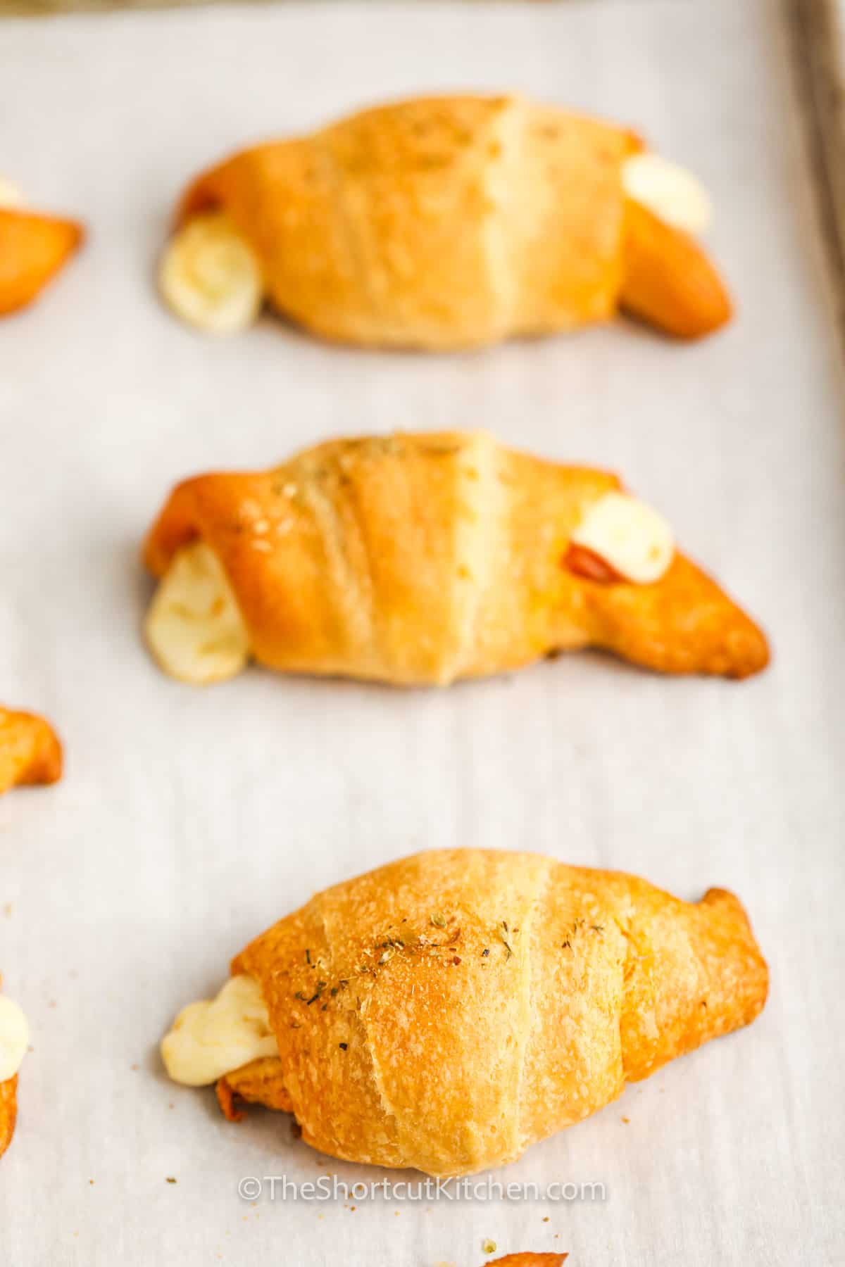 Baked pepperoni pizza rolls on a baking tray