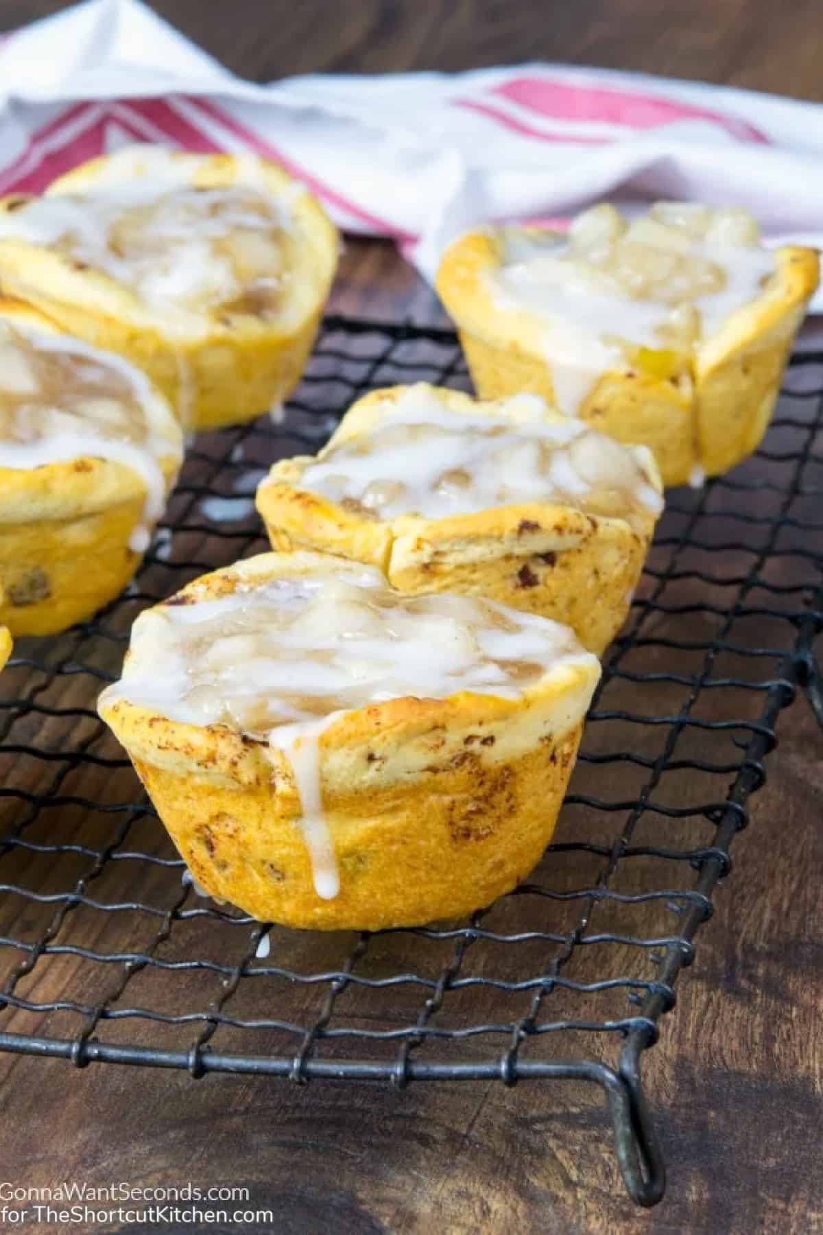 Cinnamon Roll Apple Pie Bites on a cooling rack with icing