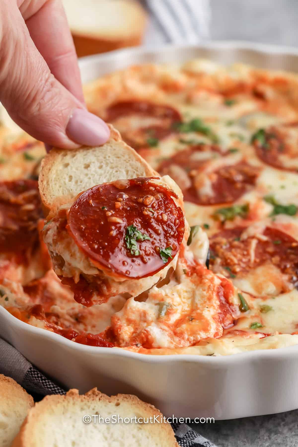 Cheesy Pizza Dip being scooped with a slice of bread