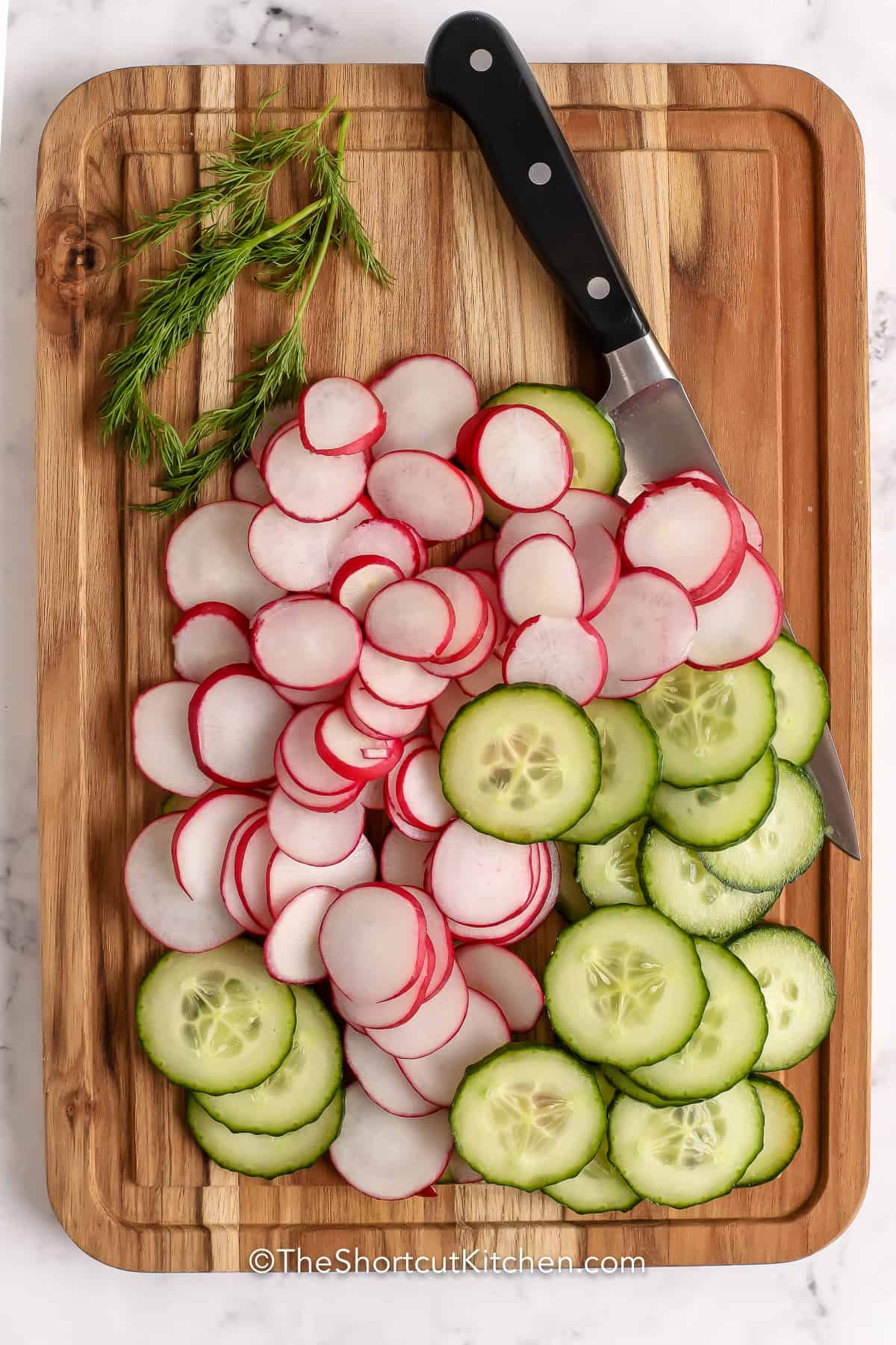 chopped cucumber and radish on a cutting board