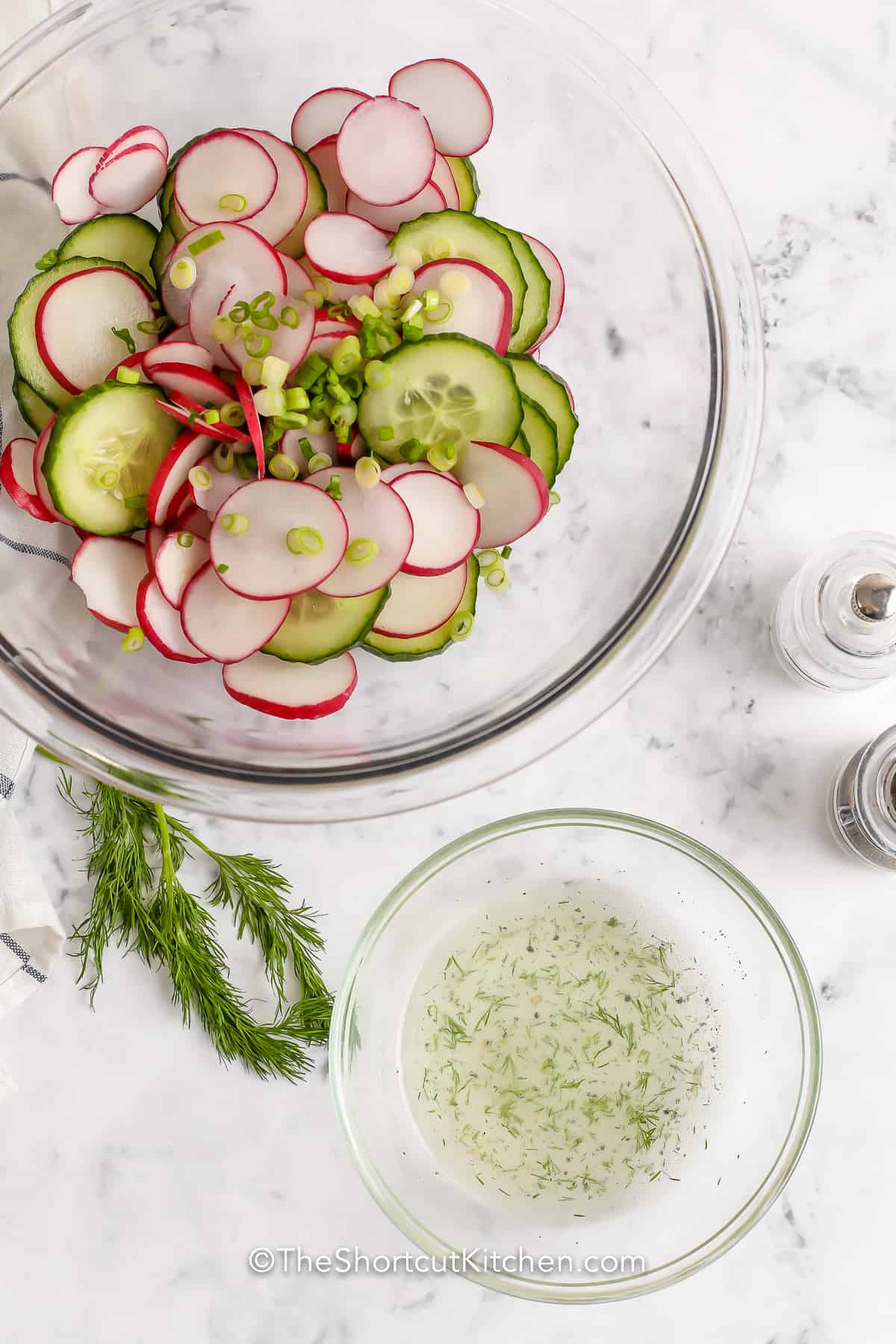 chopped cucumber and radish in a bowl next to dressing