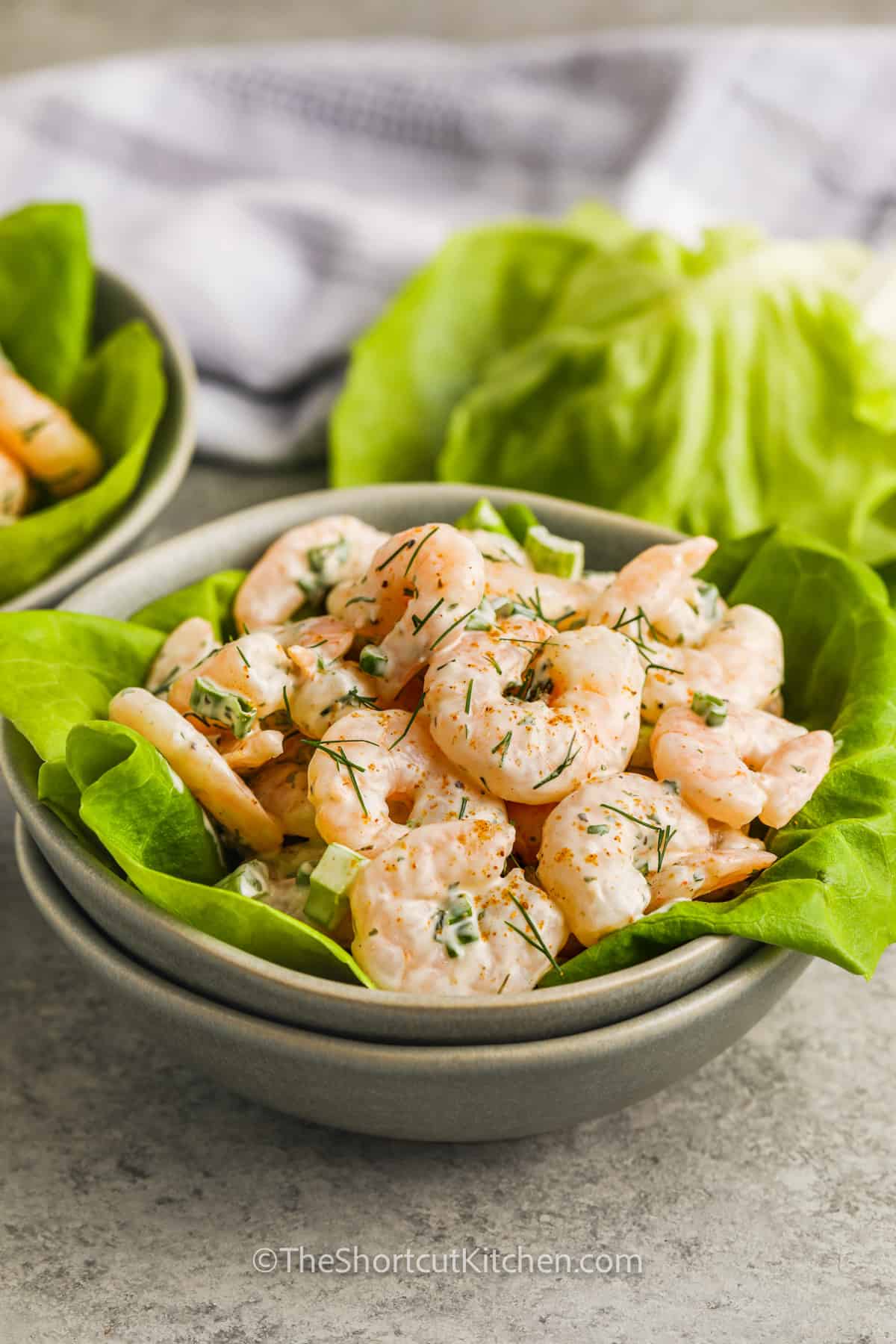 A bowl of shrimp salad served on lettuce