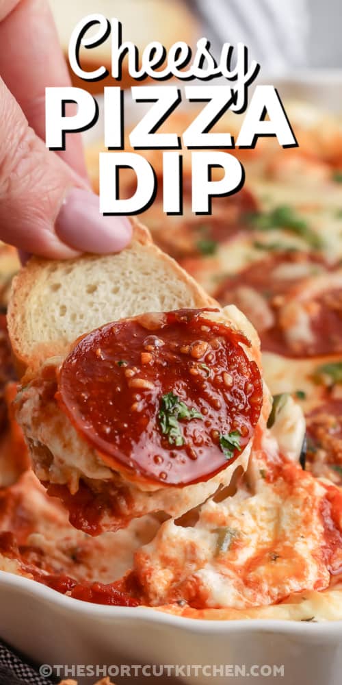 Cheesy Pizza Dip being scooped with a slice of baguette with a title