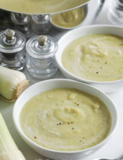 bowls of Cauliflower Leek Soup with pot full in the back