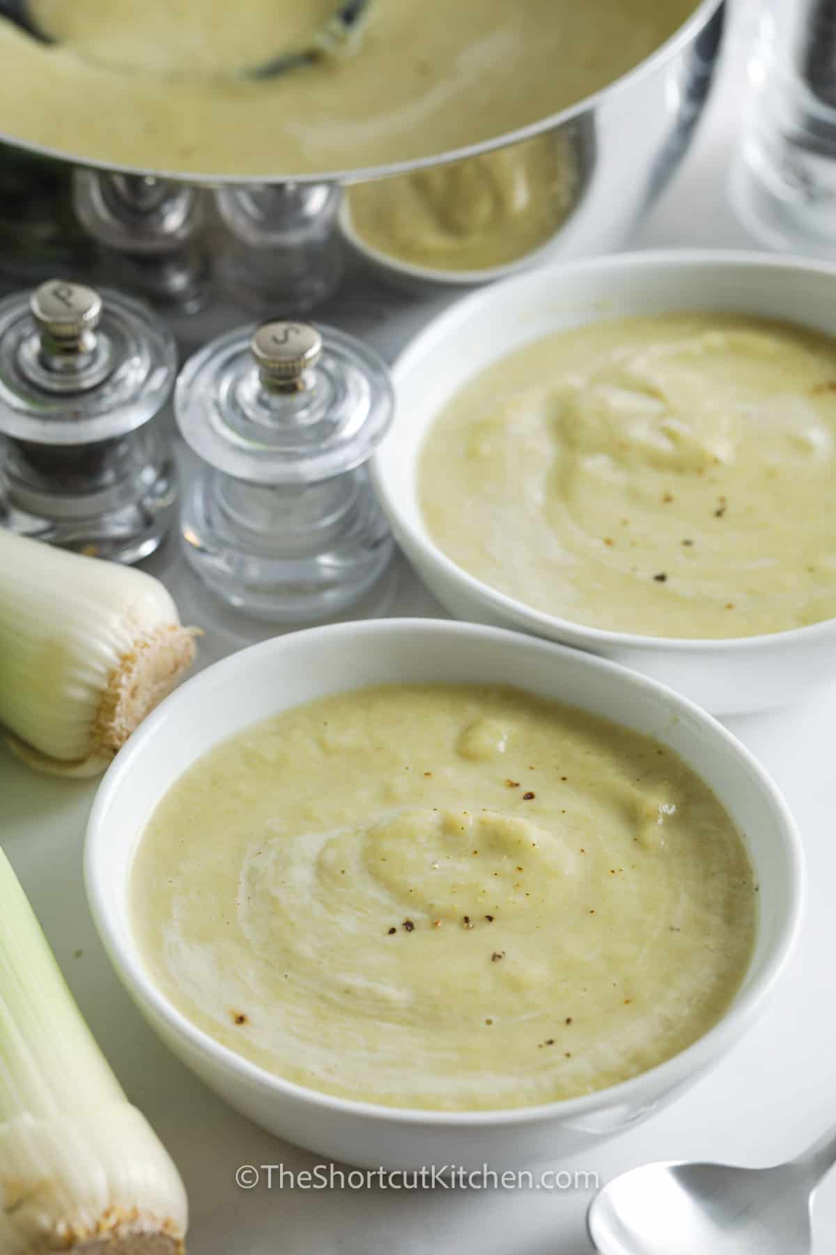 bowls of Cauliflower Leek Soup with pot full in the back