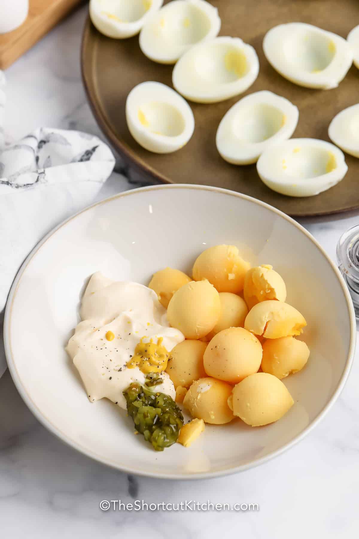 egg yolks, mayonnaise, relish, and mustard in a bowl