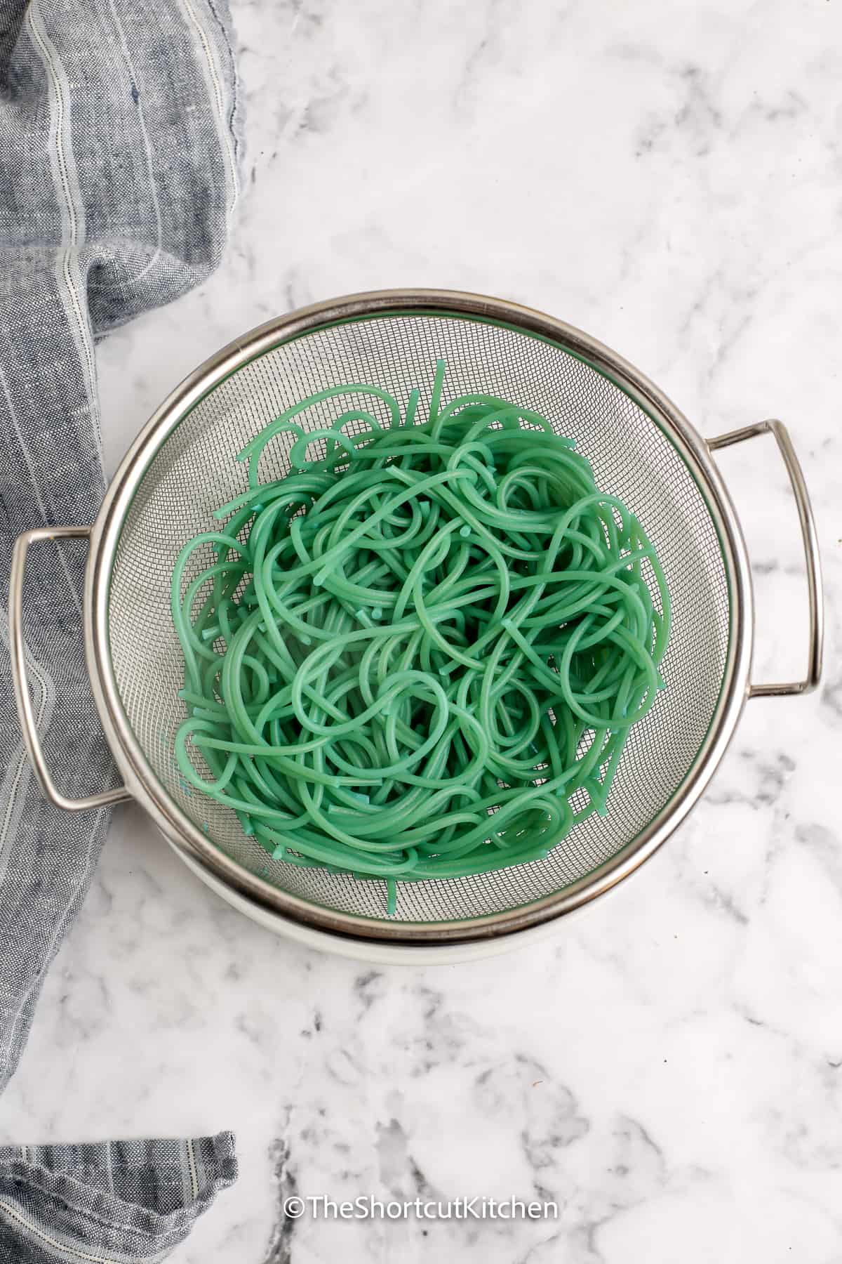 green spaghetti noodles in a colander