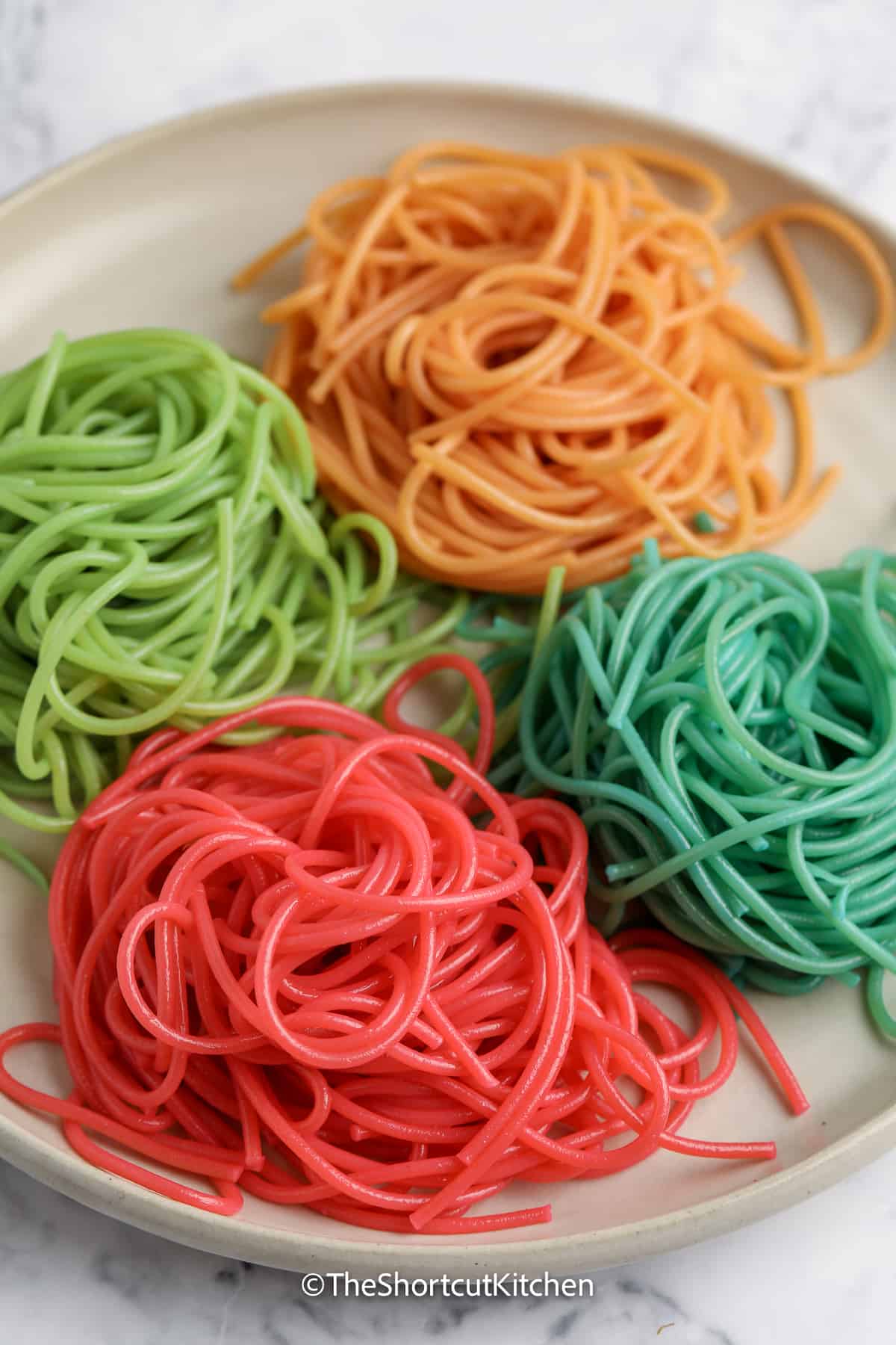 red, green, blue, and orange spaghetti noodles on a plate