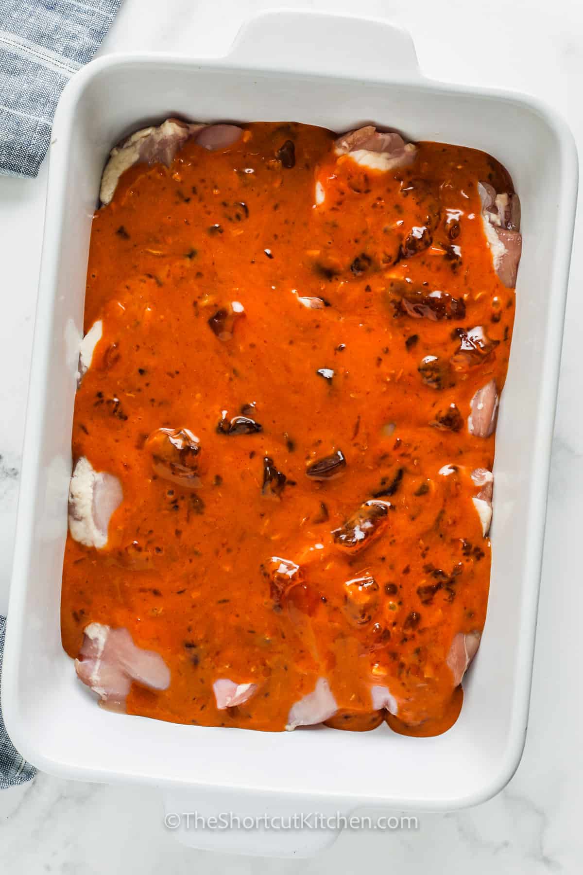 If you love sweet-tangy sauces, you’ll want this apricot chicken recipe on repeat. The simple apricot jam chicken sauce bakes into a sticky glaze with dressing and onion soup mix, no extra steps. Use wings for a party tray or thighs for the juiciest dinner. This baked apricot chicken is perfect with rice, couscous, or roasted veggies. #theshortcutkitchen adding sauce over chicken to make Apricot Chicken