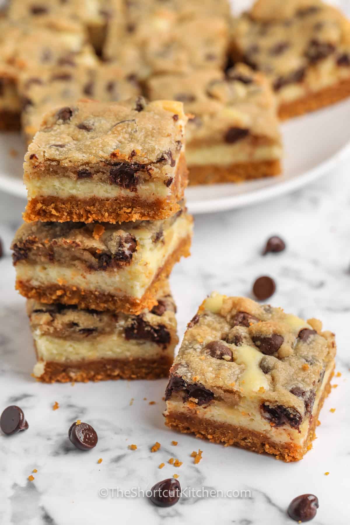 Chocolate Chip Cheesecake Bars in a pile and on a plate