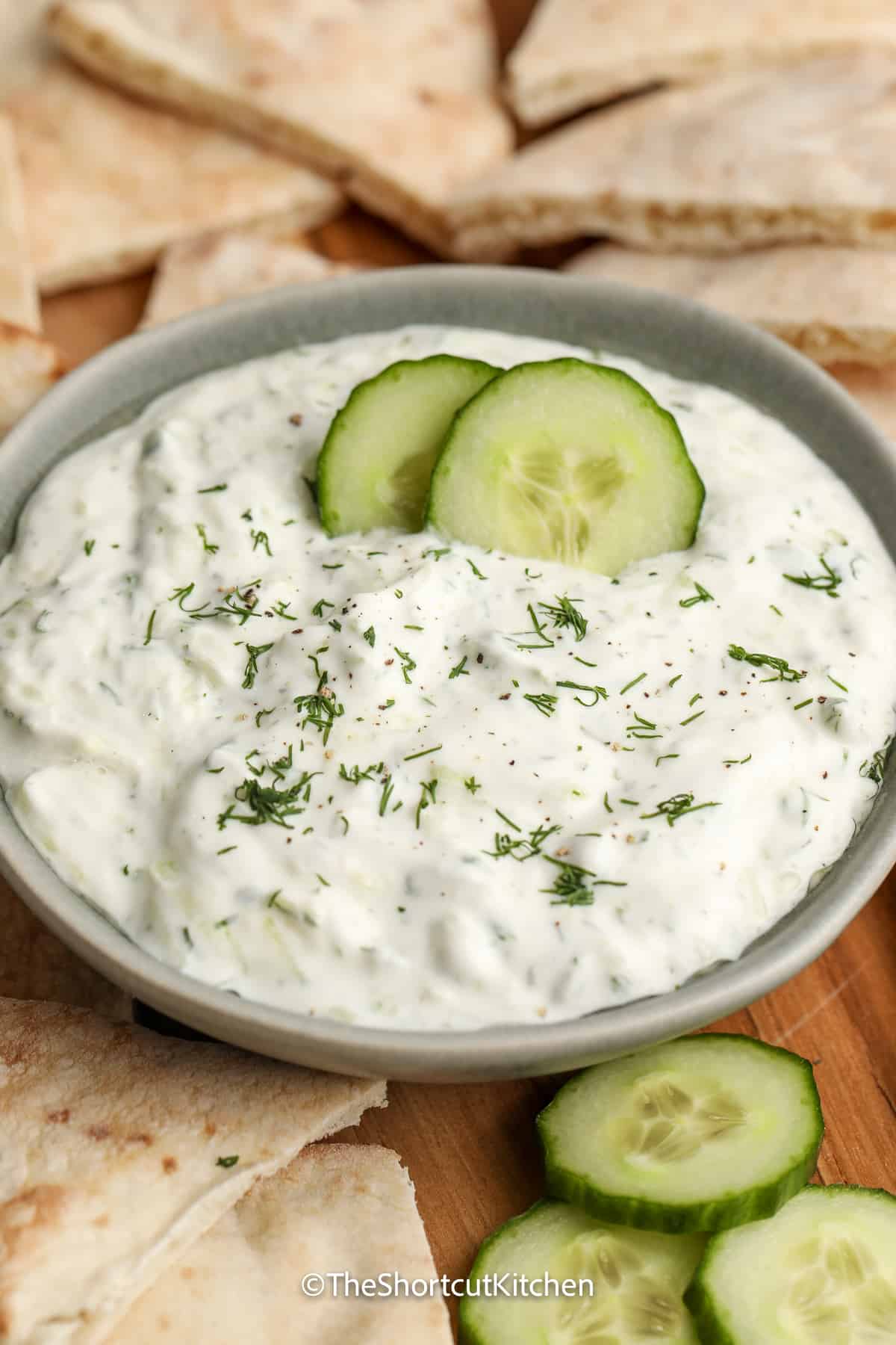 homemade tzatziki sauce with pita bread and cucumber slices