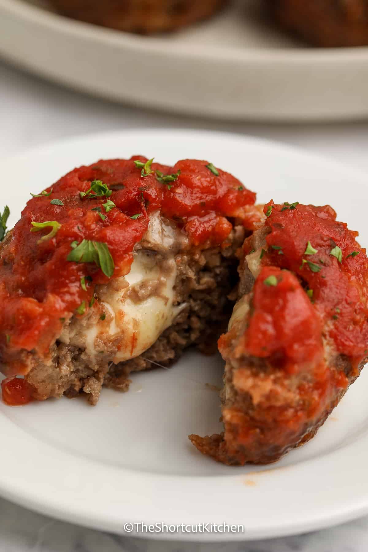 a mozzarella stuffed mini meatloaf cut in half