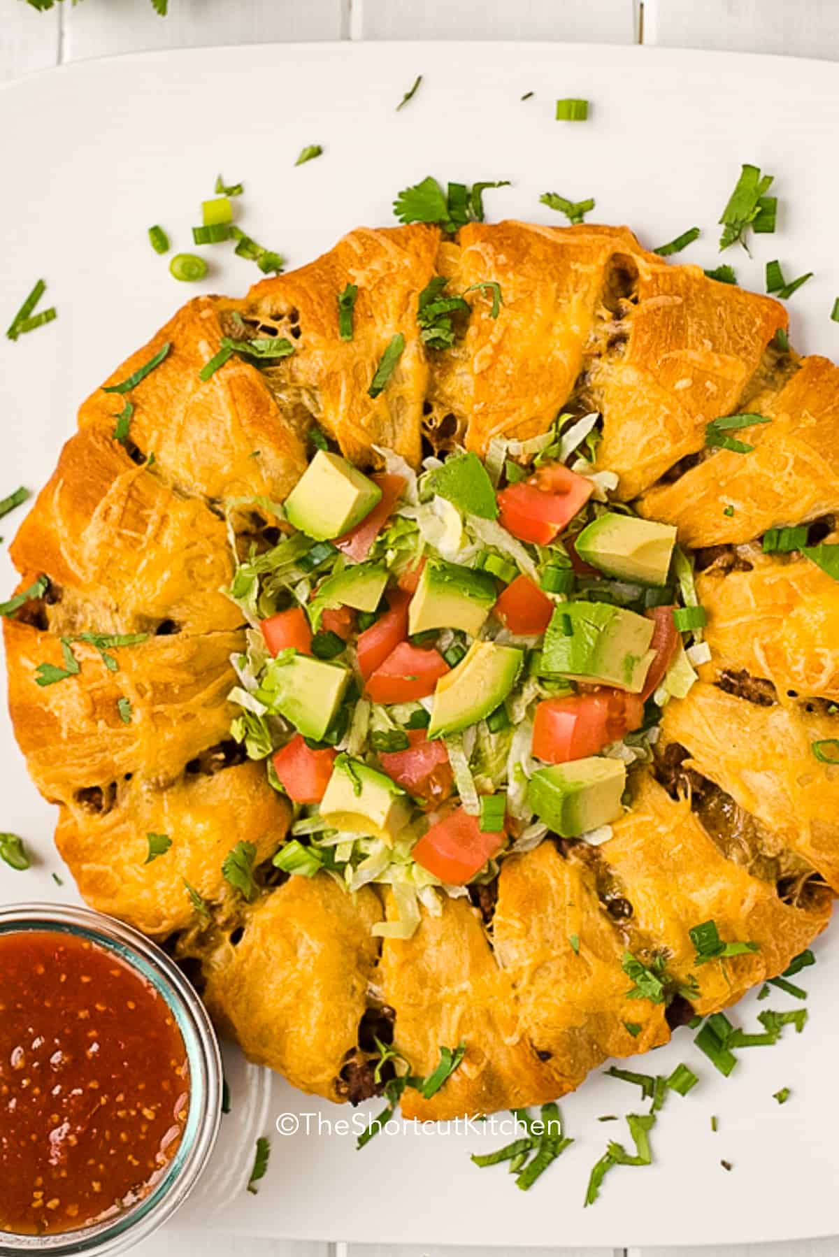 baked taco ring with taco toppings served in the center