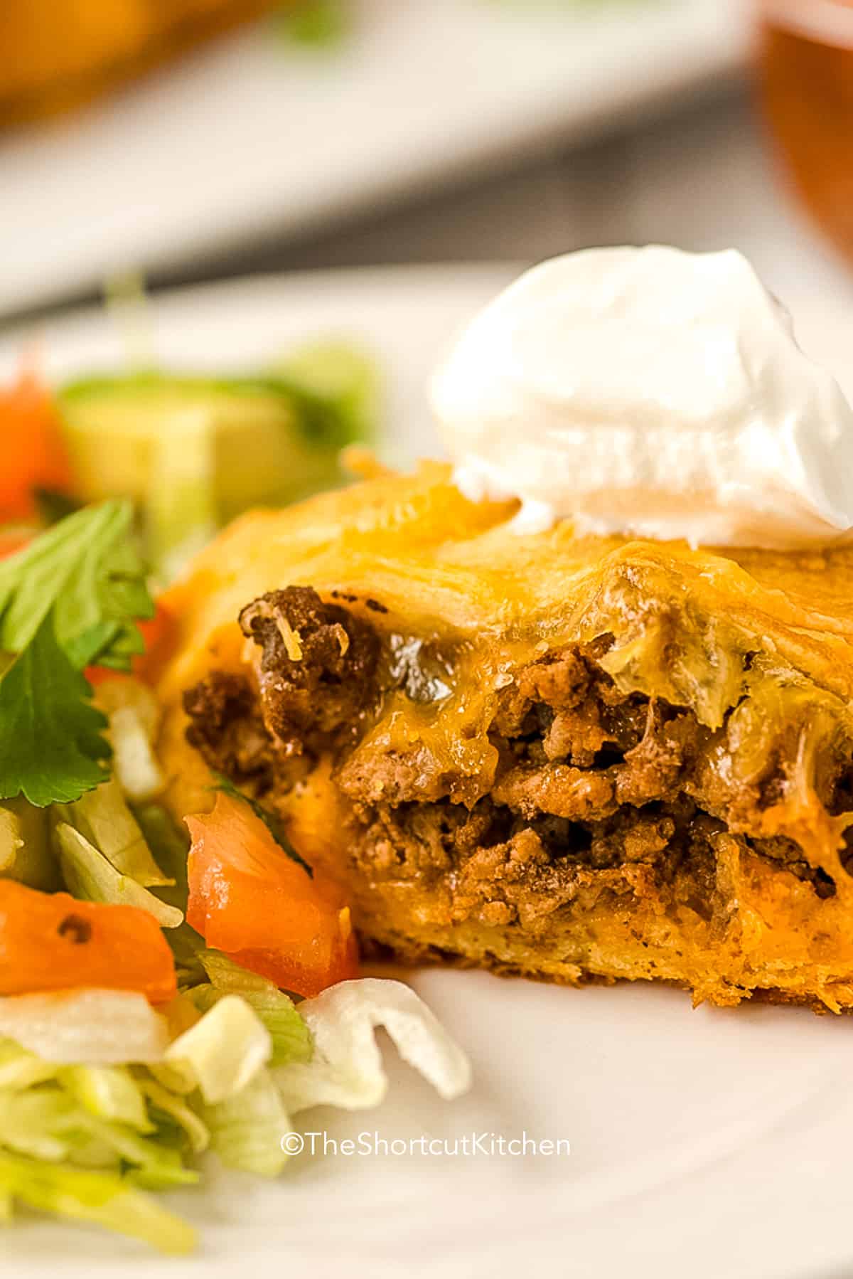 a slice of baked taco ring topped with sour cream