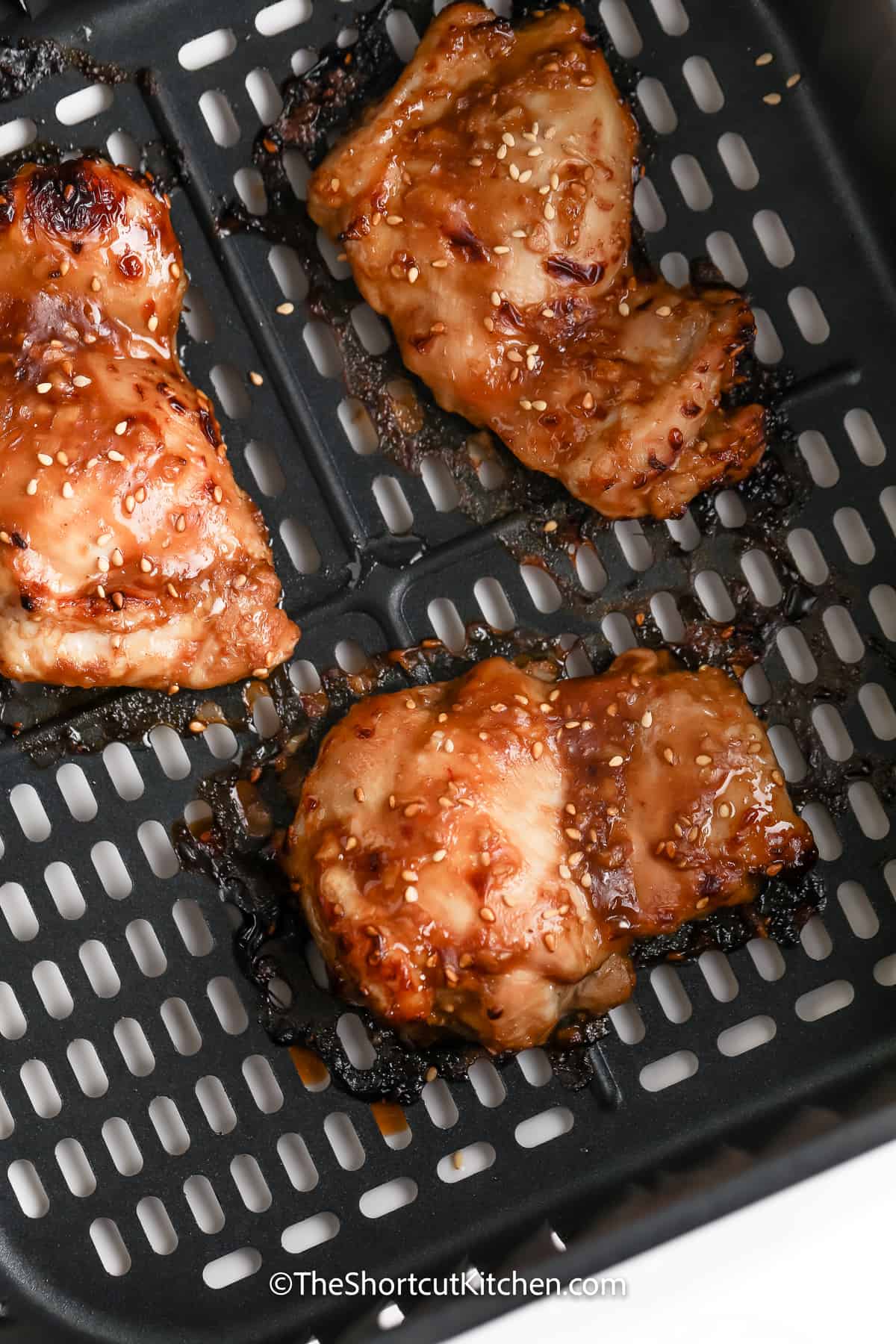 cooked chicken thighs in an air fryer tray