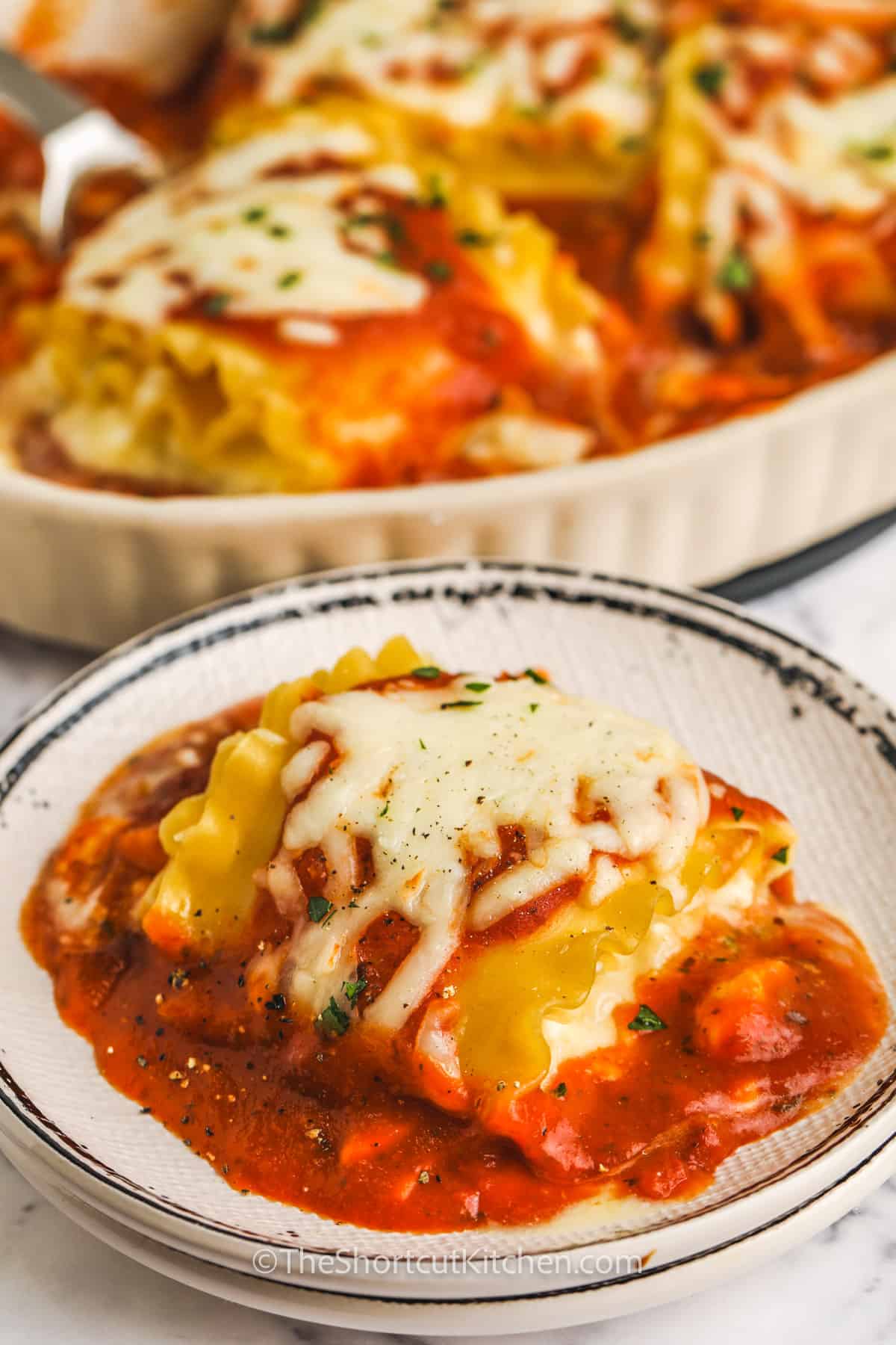 plate of Three Cheese Lasagna Rolls with pan full in the back