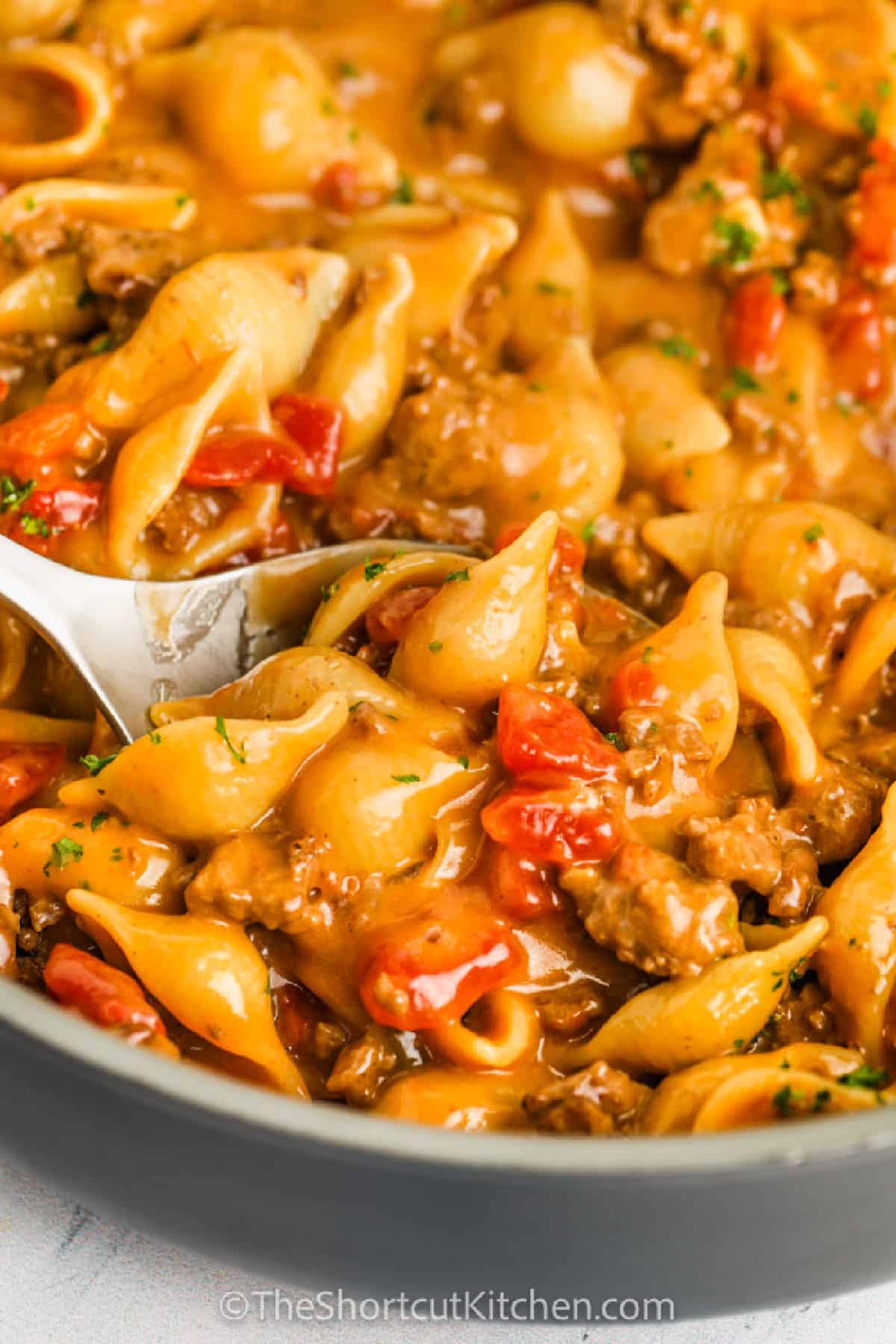 Cheesy Ground Beef Pasta being served with a silver spoon