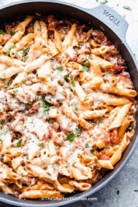 Italian Sausage Pasta in a skillet, garnished with fresh parsley