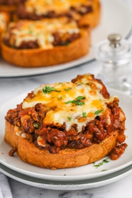 cooked Texas Toast Sloppy Joes on a plate with plate full in the back