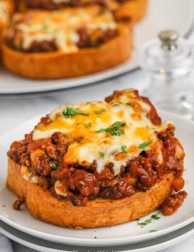cooked Texas Toast Sloppy Joes on a plate with plate full in the back