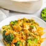 plated Baked Broccoli and Cheese Casserole with dish in the back