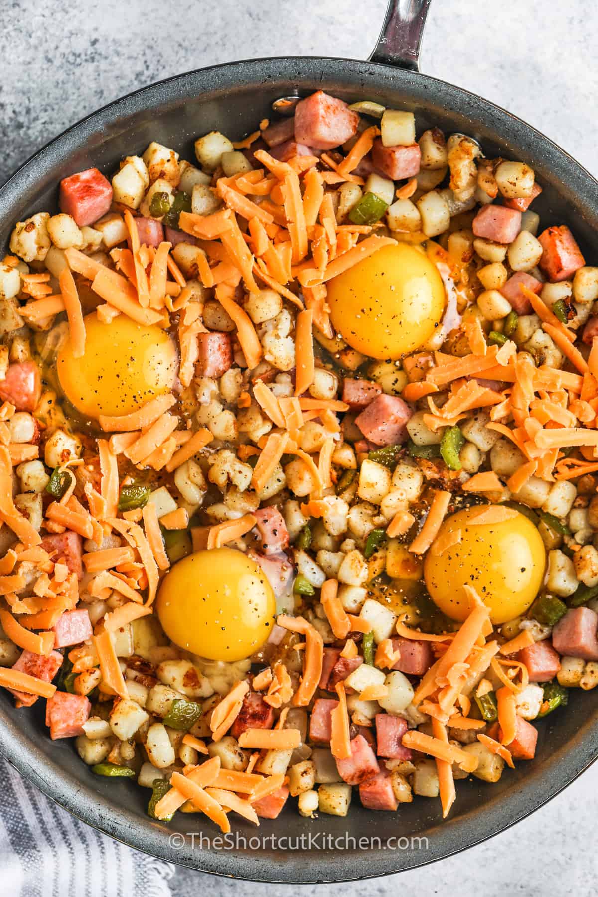 adding eggs to pan to make Breakfast Hash With Ham