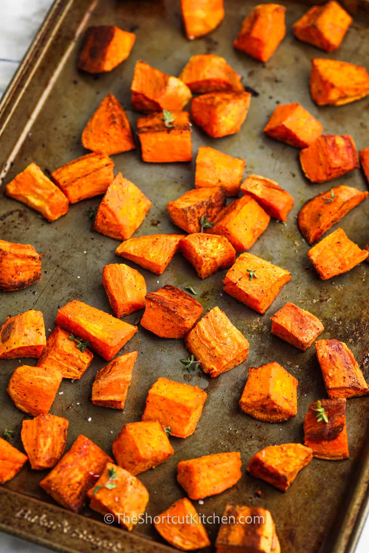 close up of Oven Roasted Sweet Potatoes cooked on a baking sheet