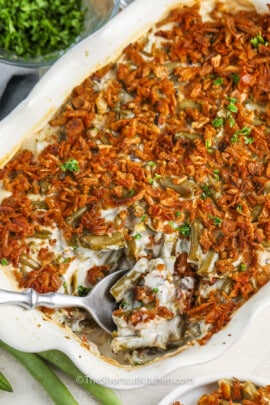 taking a spoonful of Canned Green Bean Casserole out of the casserole dish