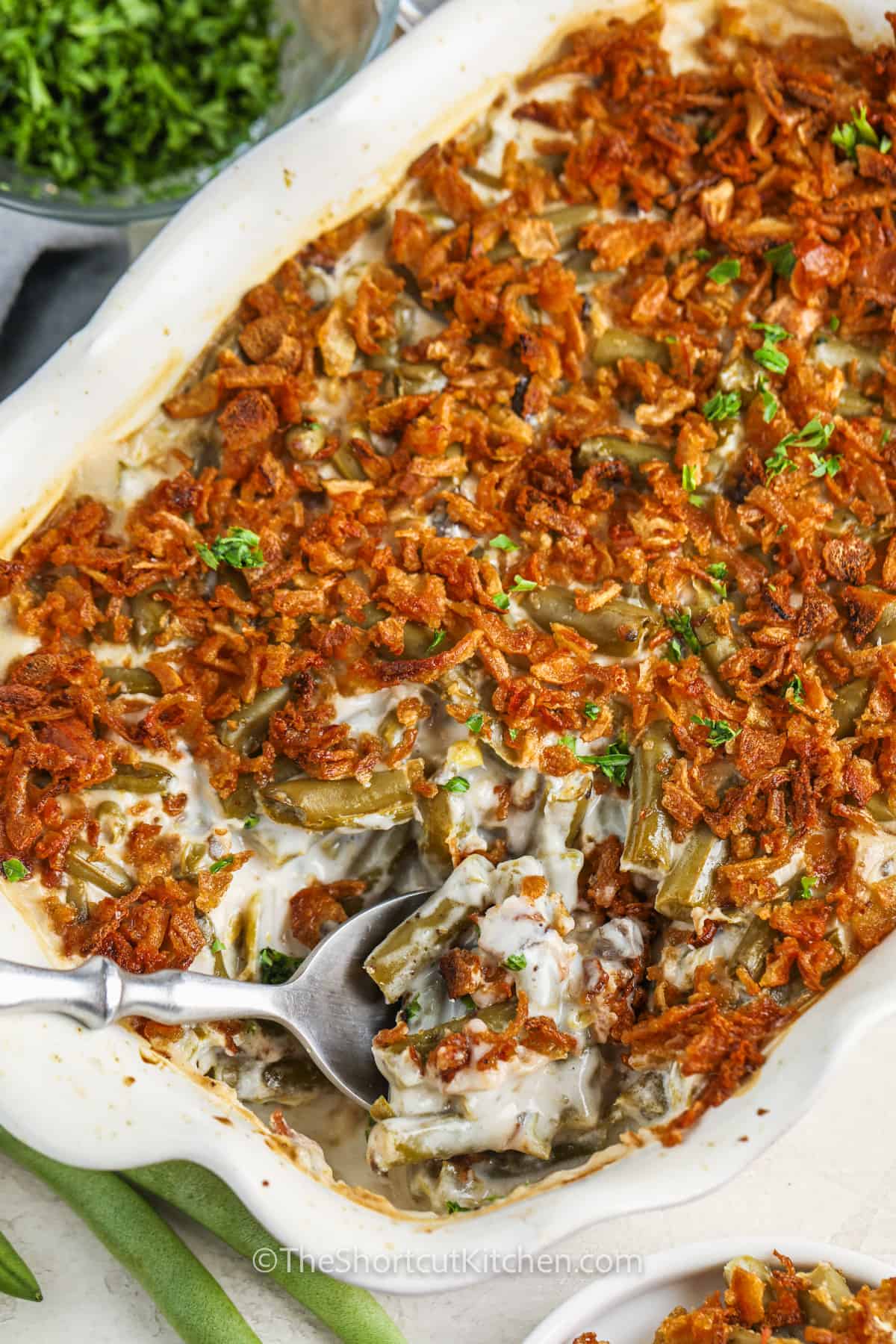 taking a spoonful of Canned Green Bean Casserole out of the casserole dish