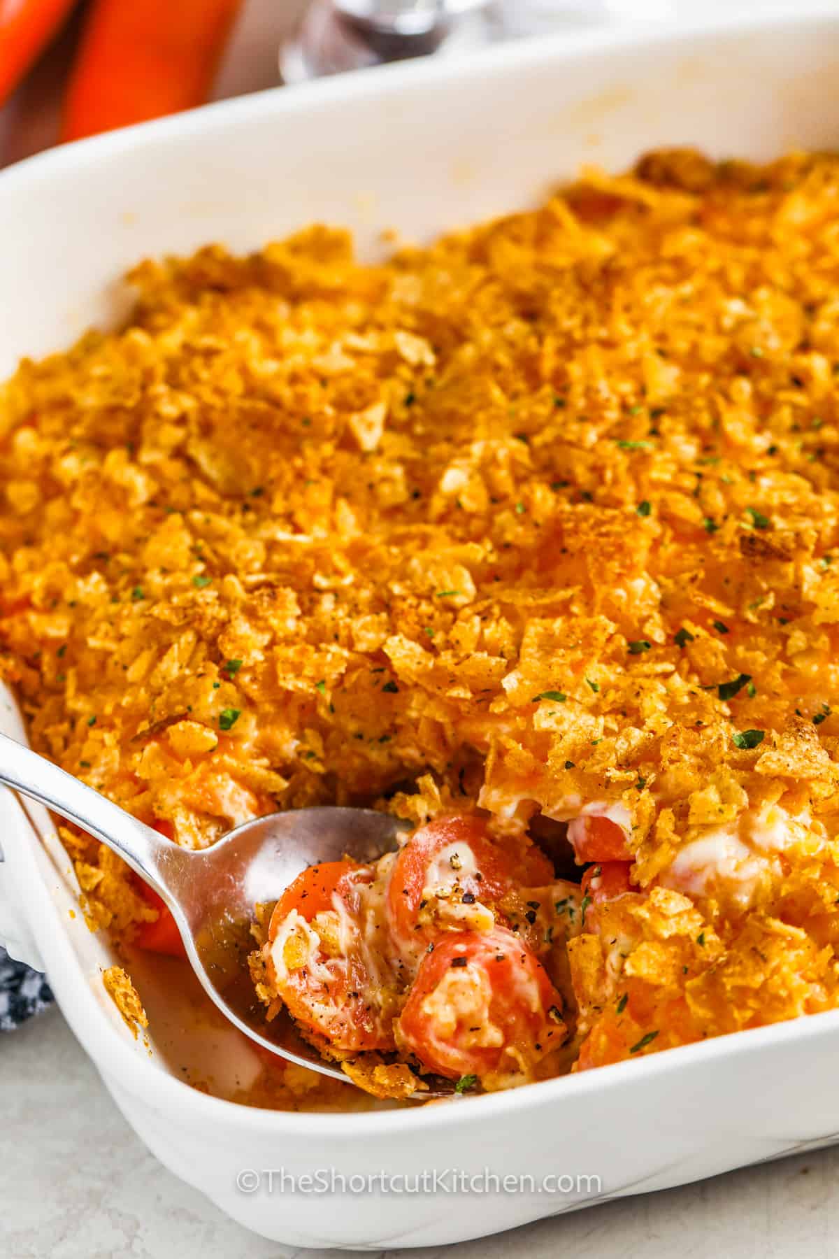 close up of Carrot Casserole in a casserole dish with a spoon taking some out