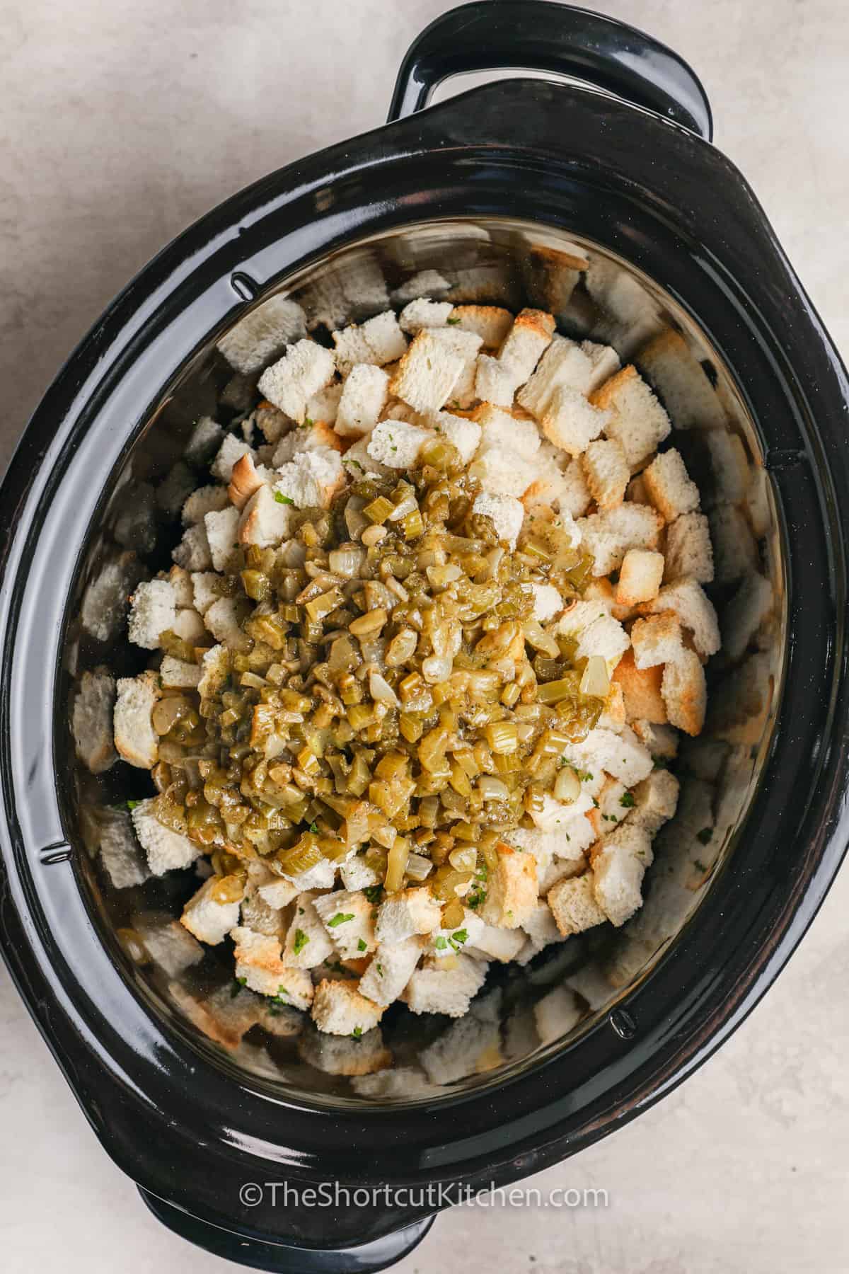adding ingredients to pot to make Easy Slow Cooker Stuffing