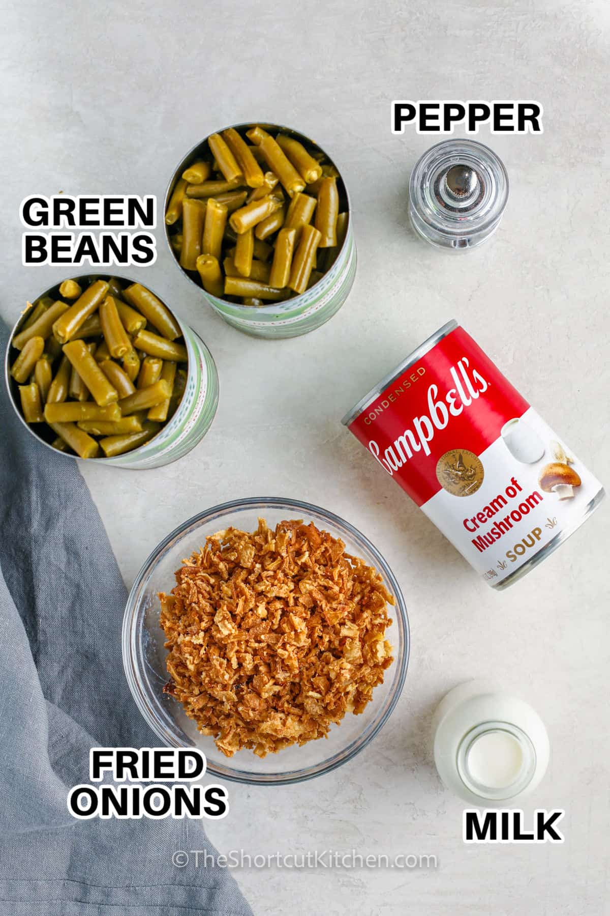 canned green beans , pepper , fried onions , cream of mushroom soup and milk with labels to make Canned Green Bean Casserole