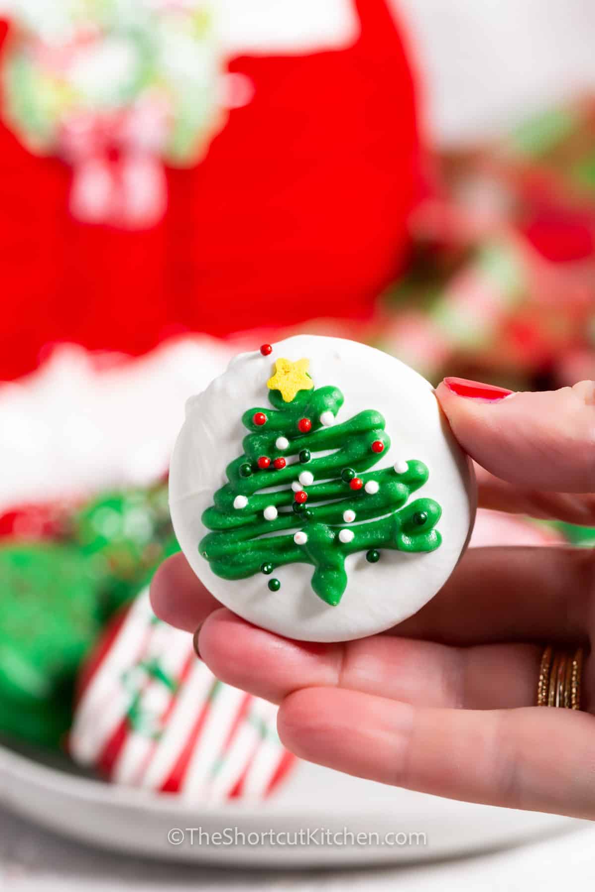 Christmas Dipped Oreos with one cookie in a hand