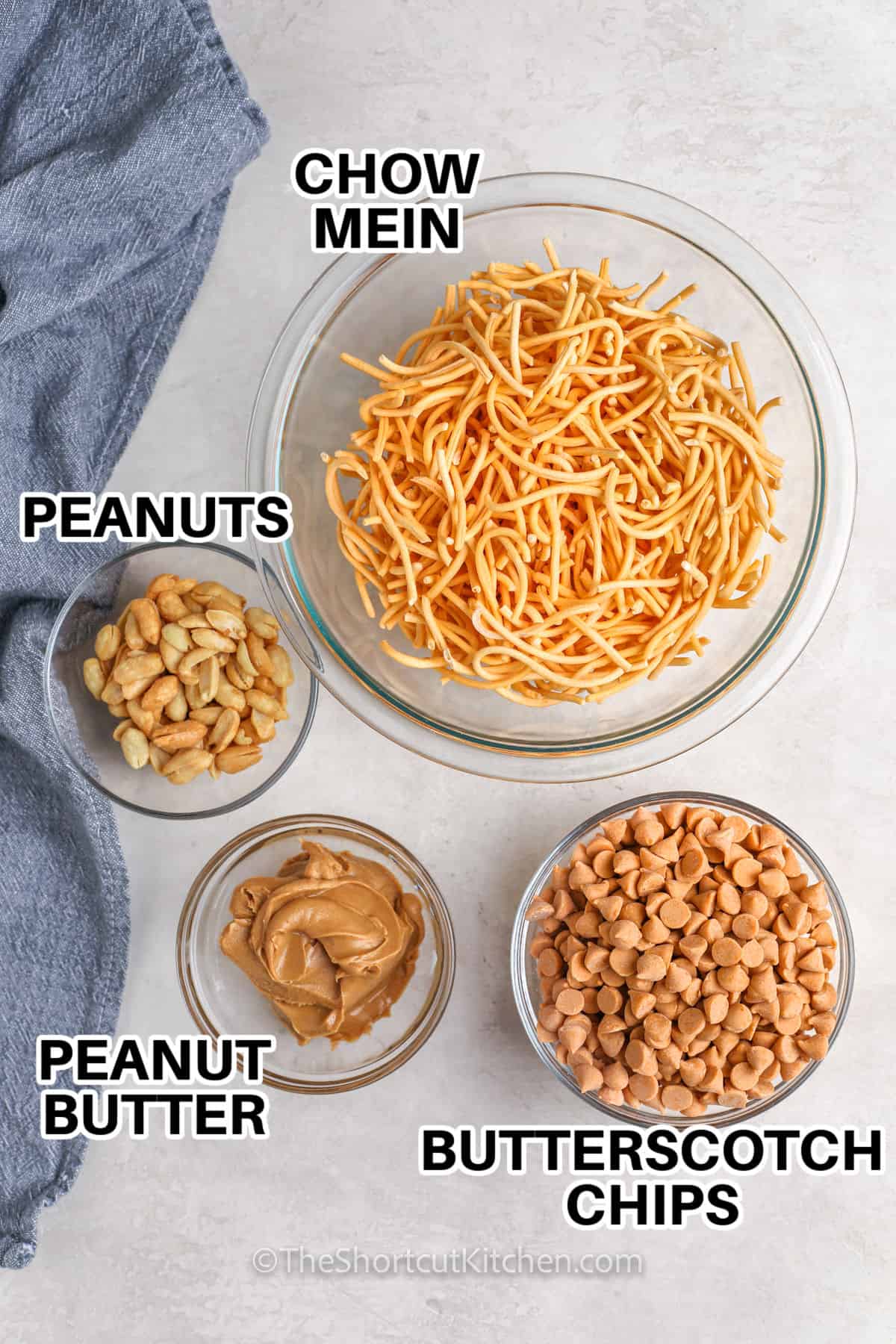 peanut butter , peanuts , chow mein , butterscotch chips in bowls to make Butterscotch Haystacks with labels