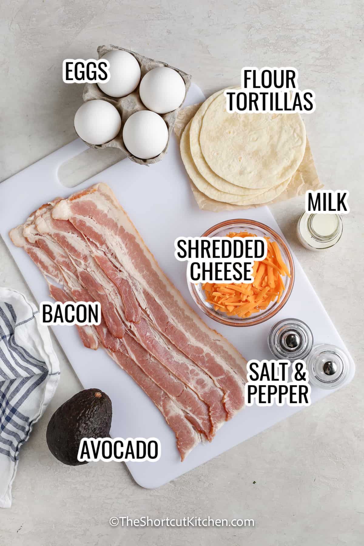 ingredients assembled to make east breakfast tacos, including eggs, bacon, avocado, flour tortillas, shredded cheese, and milk