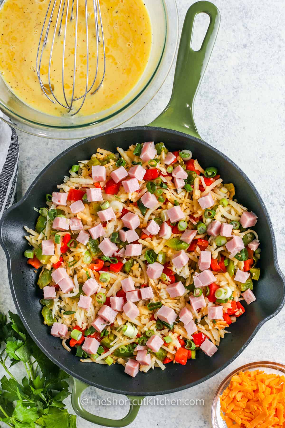 adding ham and hash browns to vegetables in pan to make Easy Egg Frittata Recipe