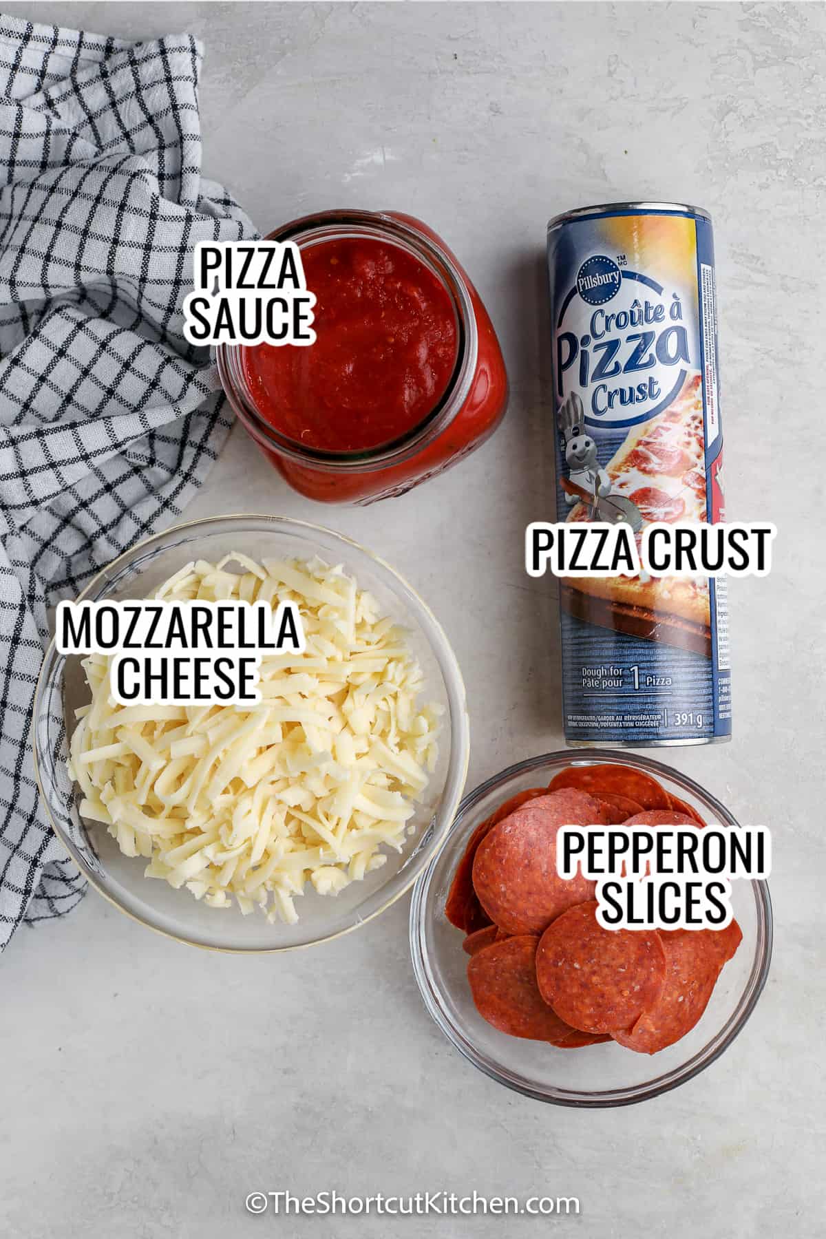 ingredients assembled to make pizza roll up, including pizza sauce, dough, mozzarella cheese, and pepperoni slices