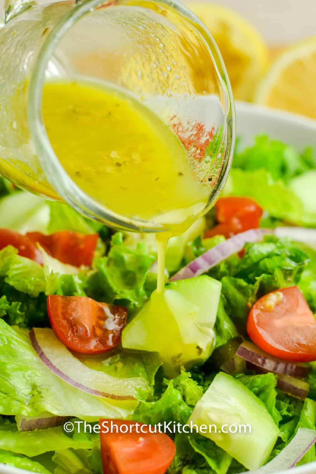 Lemon vinaigrette poured over a fresh garden salad