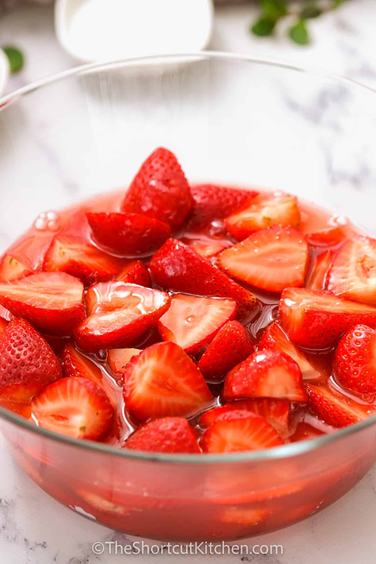 marinating strawberries in a bowl to make Fresh Strawberry Pie
