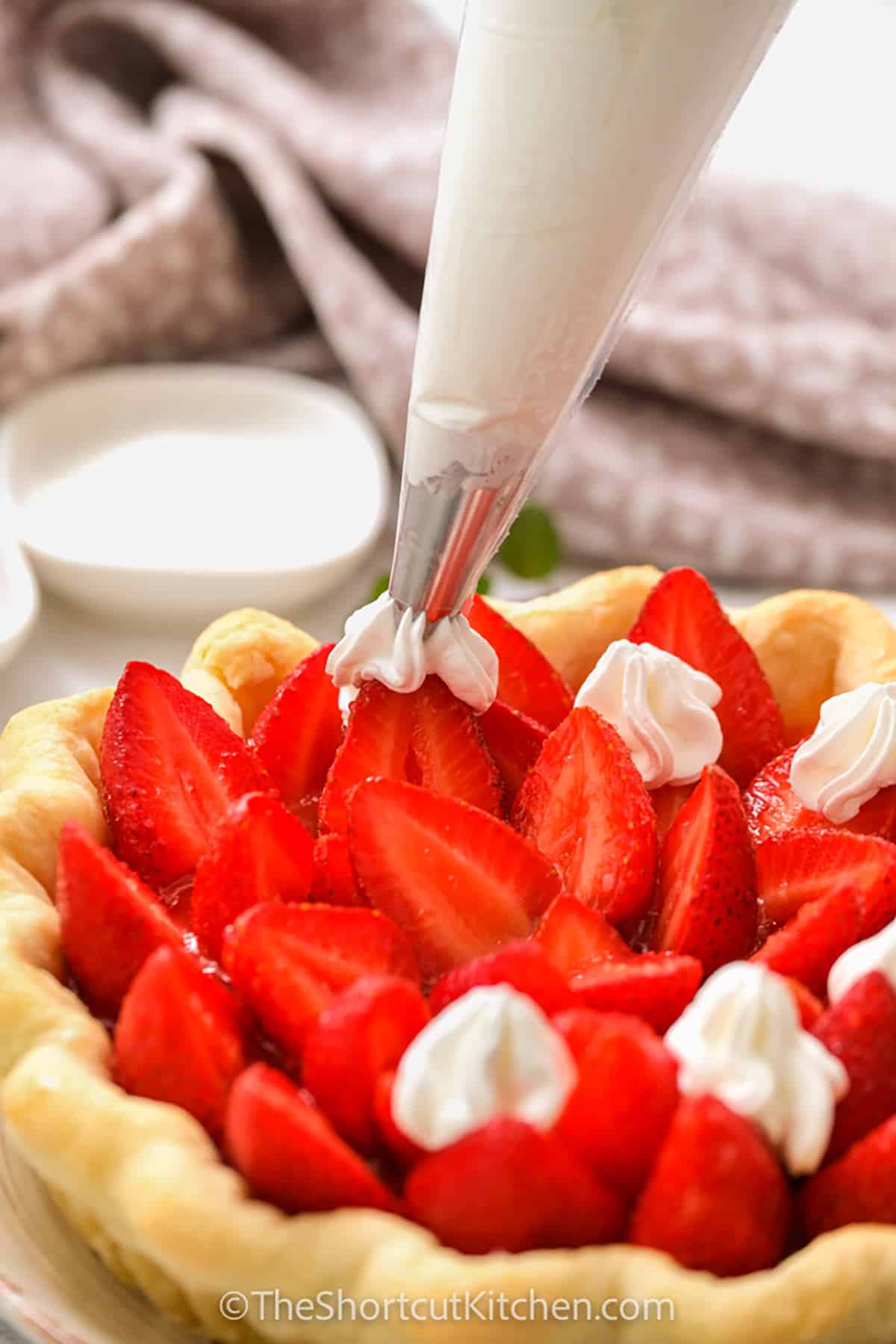 adding whipped cream to Fresh Strawberry Pie