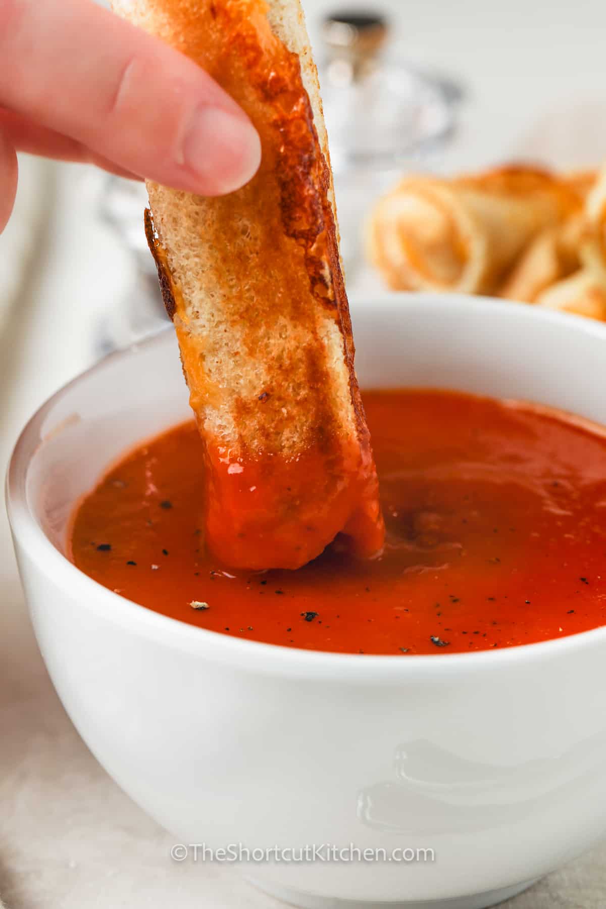 dipping Grilled Cheese Roll Ups in tomato soup